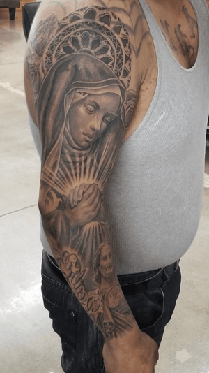 Incredible black and gray tattoo of Jesus and Maria by tattoo artist Jake Masri. Stunning realism and intricate detail.