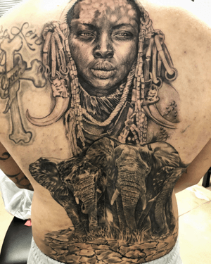 Stunning black and gray tattoo by Jake Masri featuring a detailed elephant and woman with earrings, in a realistic illustrative style.