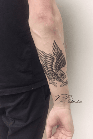 Exquisite blackwork eagle design by Patrick Bates, combining traditional and illustrative styles on the forearm.