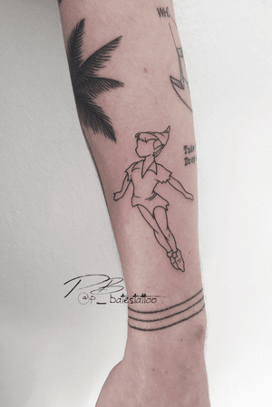 Fine line forearm tattoo featuring Peter Pan inspired boy, created by artist Patrick Bates.