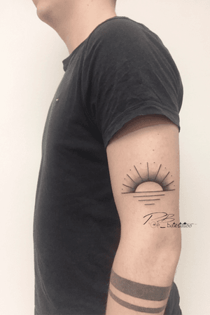 Get a stunning illustrative sun tattoo on your upper arm by renowned artist Patrick Bates. Embrace the energy of the sun with this fine line design.