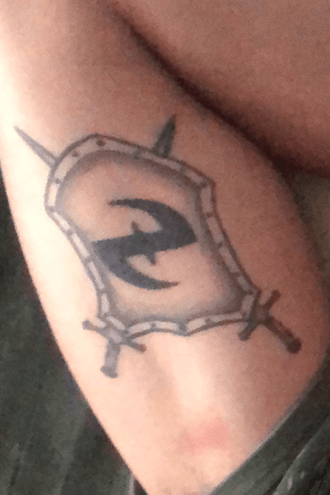 Escudo medieval com o símbolo da banda Evanescence no bíceps direito.