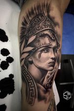 Tatuaje Realista de diosa Atenea en negros en biceps hombre. Tatuajes Realistas & New School de Santi H en Madrid