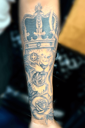 Lion tattoo with crown and rose..