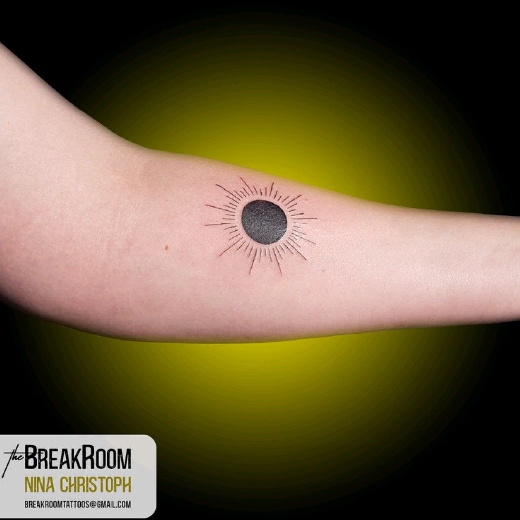 Minimalistic style eclipse tattoo done on the tricep