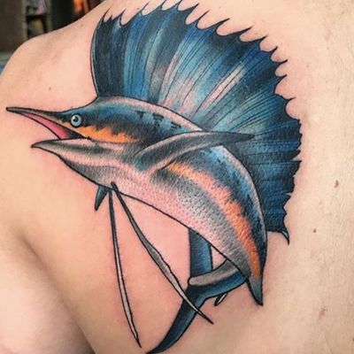 Immerse yourself in the ocean with this illustrative upper back tattoo of a majestic marlin swimming in the deep blue sea. By renowned artist Darren Brass.