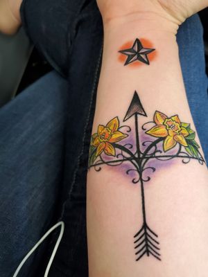 Bow & Arrow with Daffodils, aimed at a nautical/texas star When life pulls you back, it's going to shoot you to the stars. Daffodils symbolize rebirth and new beginnings. Emphasizing the bow and arrow metaphor. The nautical star represents adventure. It also is a nod to Texas, where my star-crossed-lover lives. This piece is a double entendre. A reminder that my struggles in life will make me stronger and lead me to more adventures and success. Secondly, the unique and complicated relationship my lover and I have is not without its many challenges but we must always stay strong and aim for each other. Our biggest expression of our love is "we were made from the same star." Even if, we miss our shot, he has changed my life and allowed my true self to emerge. I always want to be reminded of that and never forget the lessons he taught me. 
