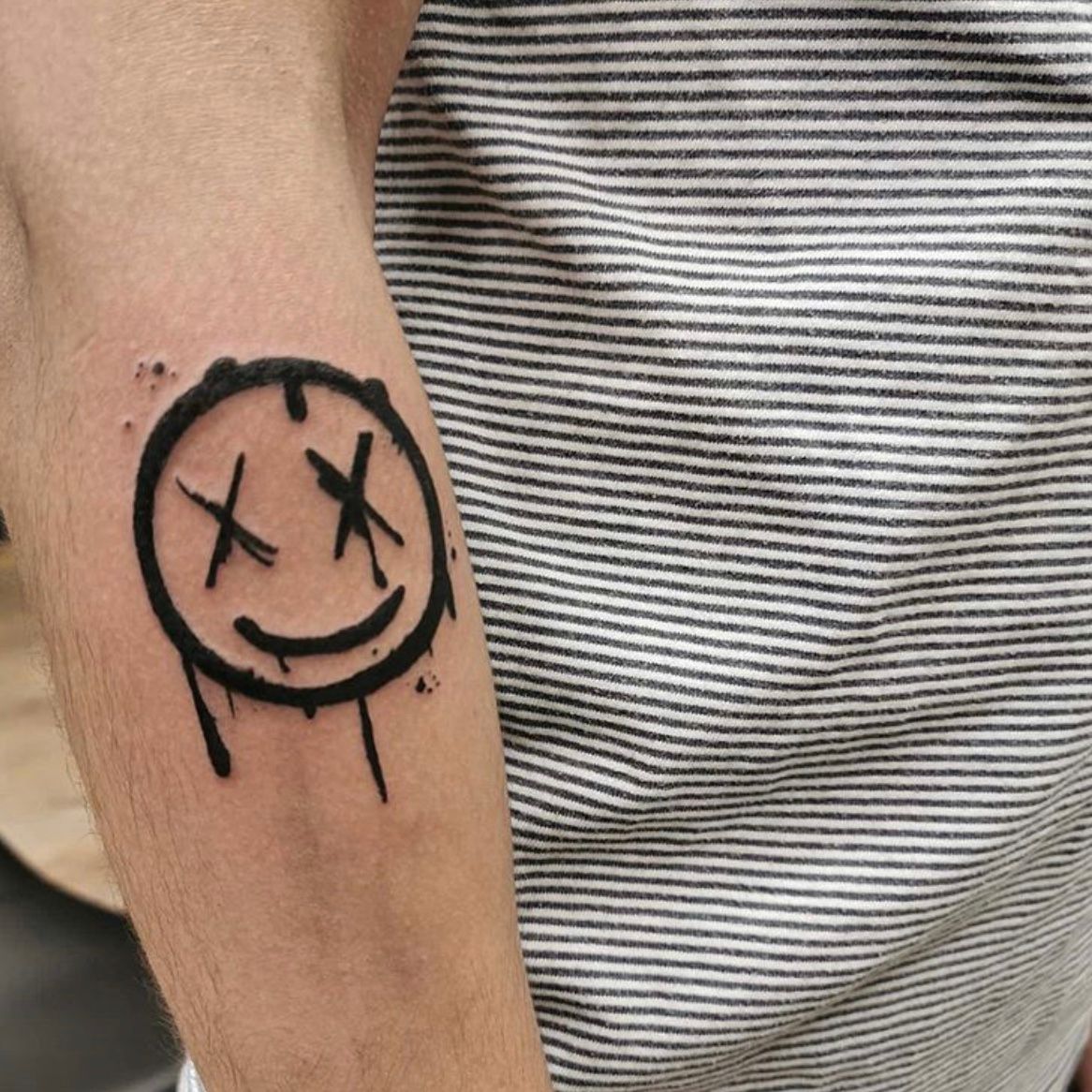 Smile lettering tattoo on the inner forearm