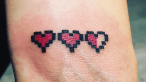 Pixel hearts on wrist 