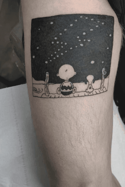 Fine line upper arm tattoo featuring Snoopy playing with a kid, beautifully executed in blackwork style by Jonathan Glick.