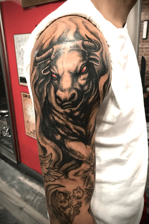 Bull tattoo in blackandgrey. Upper arm