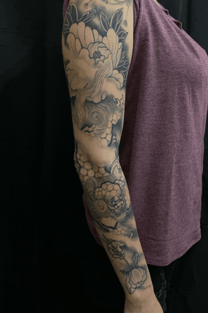 Foo dog holding a peony on a long time client.