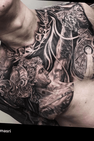 Beautiful black and gray chest tattoo of a statue head surrounded by intricate filigree, by the talented artist Jake Masri.