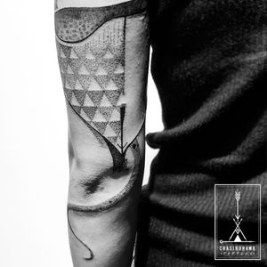 Get a mesmerizing patterned triangle tattoo on your upper arm by Chasinghawk Tattoos. Embrace the intricate dotwork design.