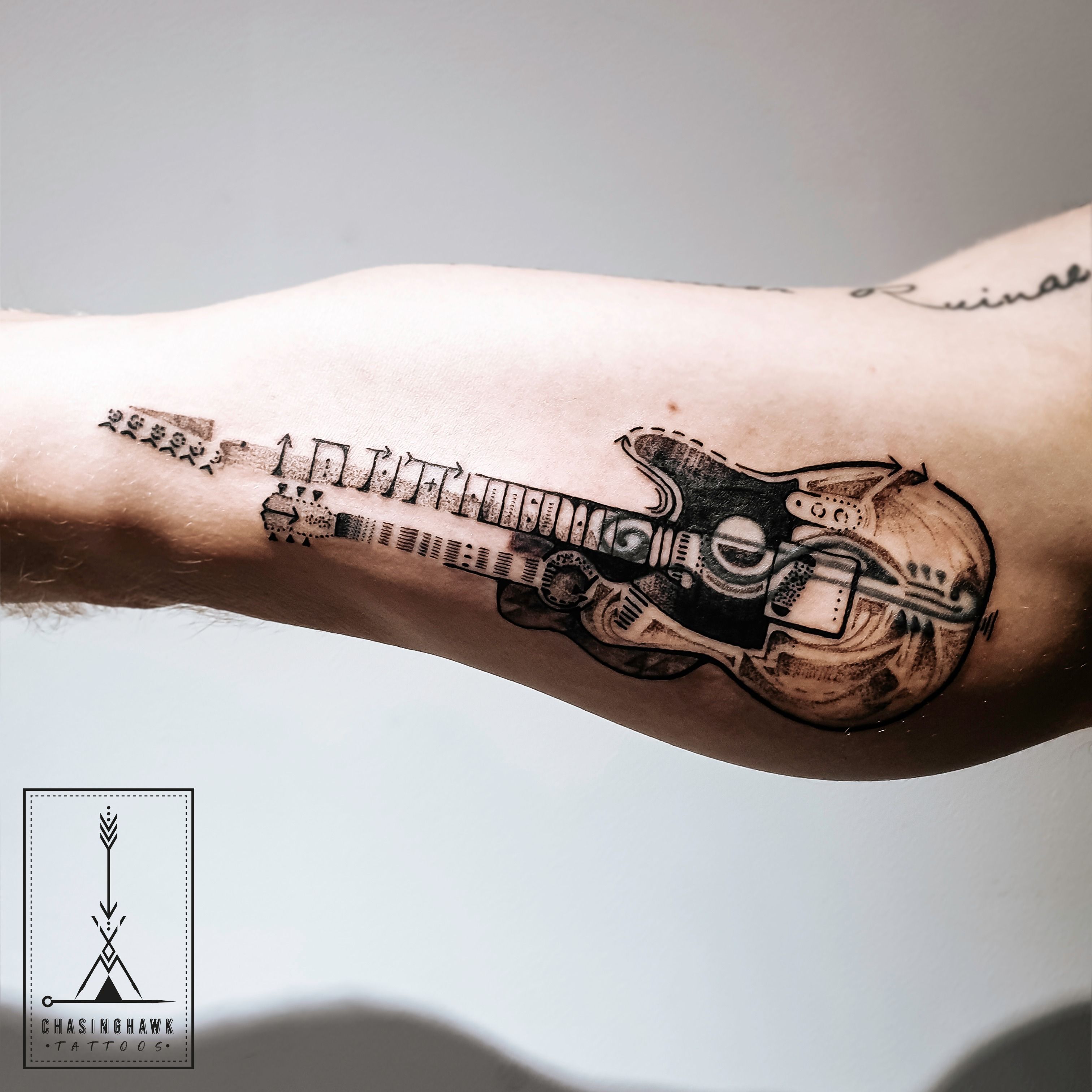 This music tattoo uses the curls of a treble clef to decorate the acoustic guitar  tattoo design | Ratta Tattoo