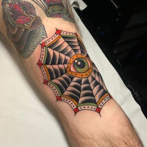 Get a stunning knee tattoo by Andrea Furci featuring a unique blend of mandala, spider web, and eye motifs in traditional Japanese style.
