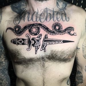A striking black and gray chest tattoo featuring a menacing snake, sharp dagger, and dripping blood, created by the talented artist Andrea Furci.