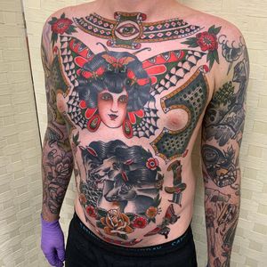 This stunning traditional tattoo on the chest features a horse, butterfly, dagger, and woman, expertly done by Andrea Furci.