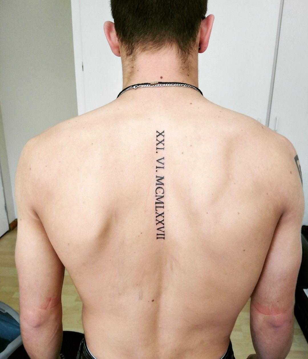 roman numeral spine tattoos for men