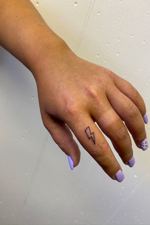 Micro lightning bolt finger tattoo