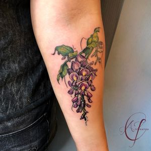 Tattoo by Andreanna Iakovidis. Wisteria Floral  Whimsical Tattoo. #wisteriatattoo #wisteria #floraltattoo #whimsicaltattoo #colorfloral #flowertattoo #femininetattoos #delicatefloraltattoo 
