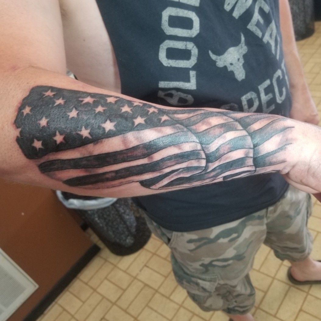 Grey Ink Ripped Skin US Flag Tattoo On Forearm
