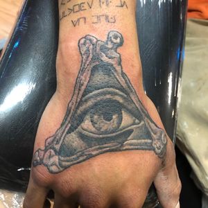 All seeing eye with bones black and gray on hand