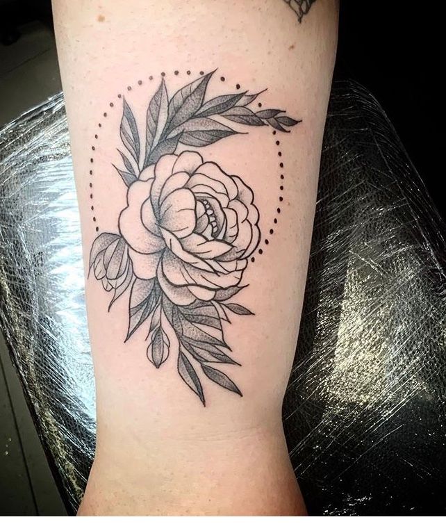 Red peony tattoo on the right inner arm.