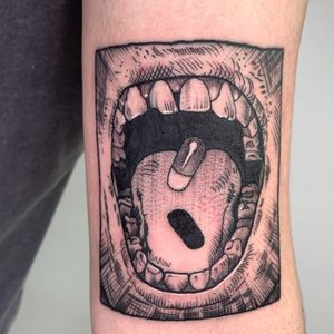 Expressive upper arm tattoo featuring teeth, pill, tongue, and lips in vibrant anime style by renowned artist Galen Bryce (aka Drip Skull).