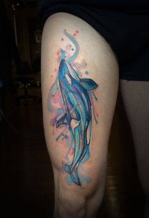 Elegant whale design on upper leg by renowned artist Aygul. Vibrant watercolor style adds a unique touch to this marine-inspired tattoo.