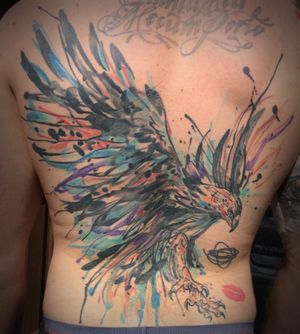 Transform your back with a stunning watercolor phoenix tattoo by the talented artist Aygul. Embrace the rebirth and renewal symbolized by this mythical creature.