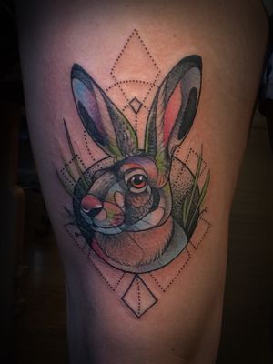Unique upper leg tattoo featuring a geometric and watercolor style rabbit, by the talented artist Aygul.