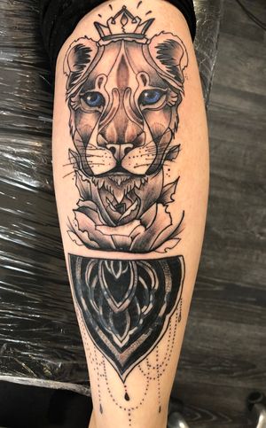 Lioness on the back of a calf with blue eyes and a cover up mandala 