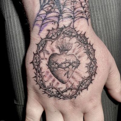 Hand tattoo by Deven Brodersen #DevenBrodersen #handtattoo #sacredheart #thorns #heart #fire 