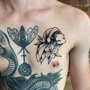 Get a stunning neo traditional chest tattoo of a beautiful woman with flowers in London, GB. Expertly designed for a timeless look.