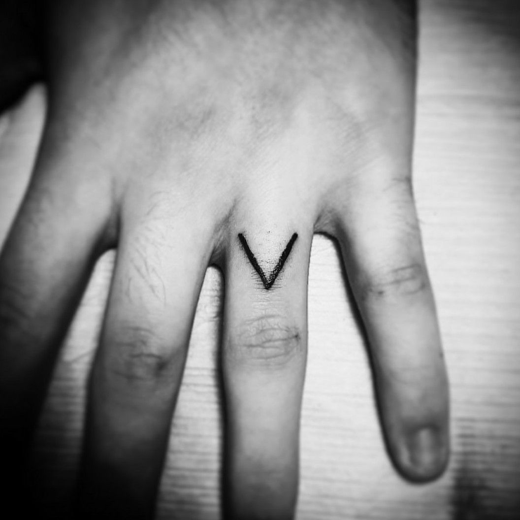 Letter M tattooed on the finger