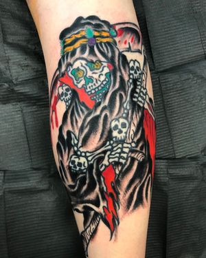 Bold traditional style tattoo of skull, grim reaper, and scythe on lower leg, by artist Felipe Reinoso.