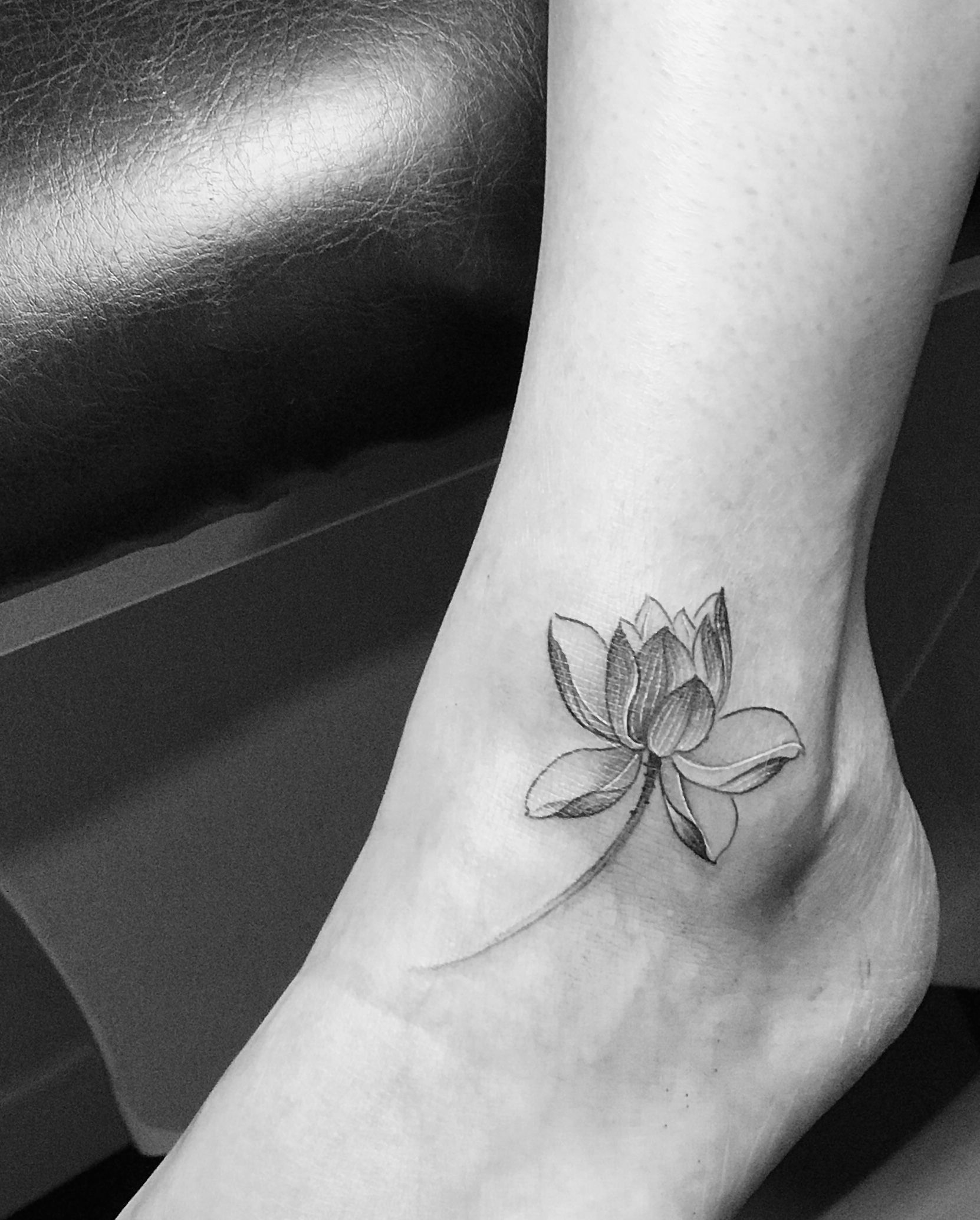 Fine line ornamental lotus flower tattoo on the ankle