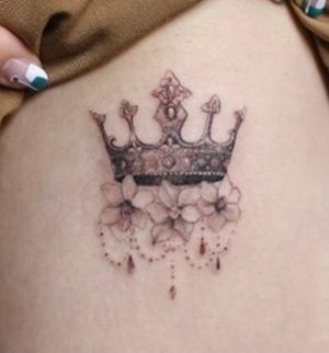 I’m looking for someone who works with fine lines, shading, florals, and detail, and likes to do delicate “feminine” pieces.
I want something similar to the picture, but with violets and water droplets. I want it small enough to fit on my wrist, but I’m happy to discuss the placement. 
I want to keep the overall structure and the intricate style, but I’d love suggestions for the design of the crown and the flowers.