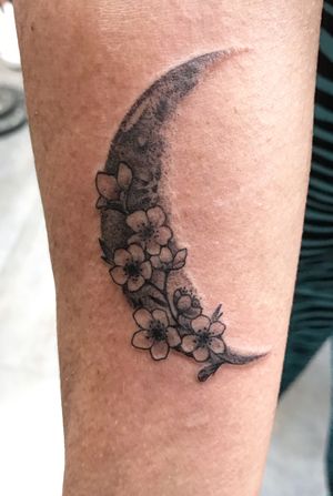 Capture the beauty of Miami with this fine line tattoo featuring a delicate moon and flower design on your forearm.