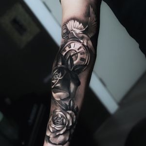 Stunning illustrative tattoo featuring a bird, flower, clock, and watch by tattoo artist Marcel Oliveira.