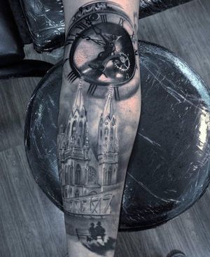 Get an impressive forearm tattoo with a realistic blackwork design of a building and clock by talented artist Marcel Oliveira.