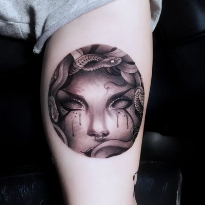 Captivating blackwork piece on upper arm featuring stunning medusa and snake design, skillfully executed by artist Marcel Oliveira.