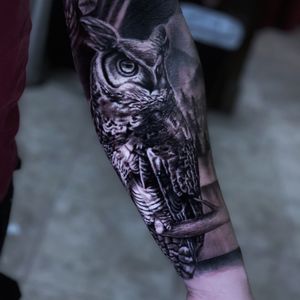 Marvel at Marcel Oliveira's stunning black and gray owl design on your forearm, blending realism and illustrative styles.