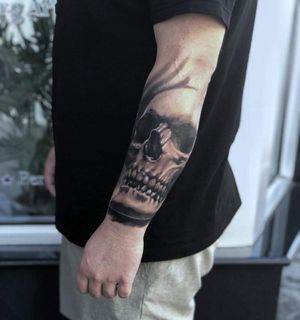 Get a stunning black and gray skull tattoo on your forearm by the talented artist Marcel Oliveira. Embrace the dark and detailed illustrative style.