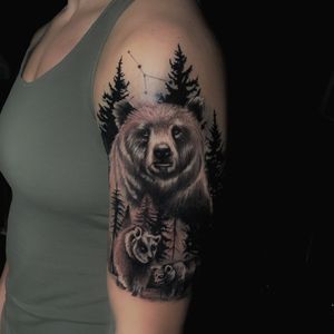 Experience the beauty of nature with this stunning black and gray tattoo by Marcel Oliveira. Featuring a detailed bear and tree design on the upper arm.