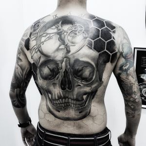 Dive into the intricate world of blackwork and realism with this stunning skull and gears back tattoo. Timeless artistry at its finest.