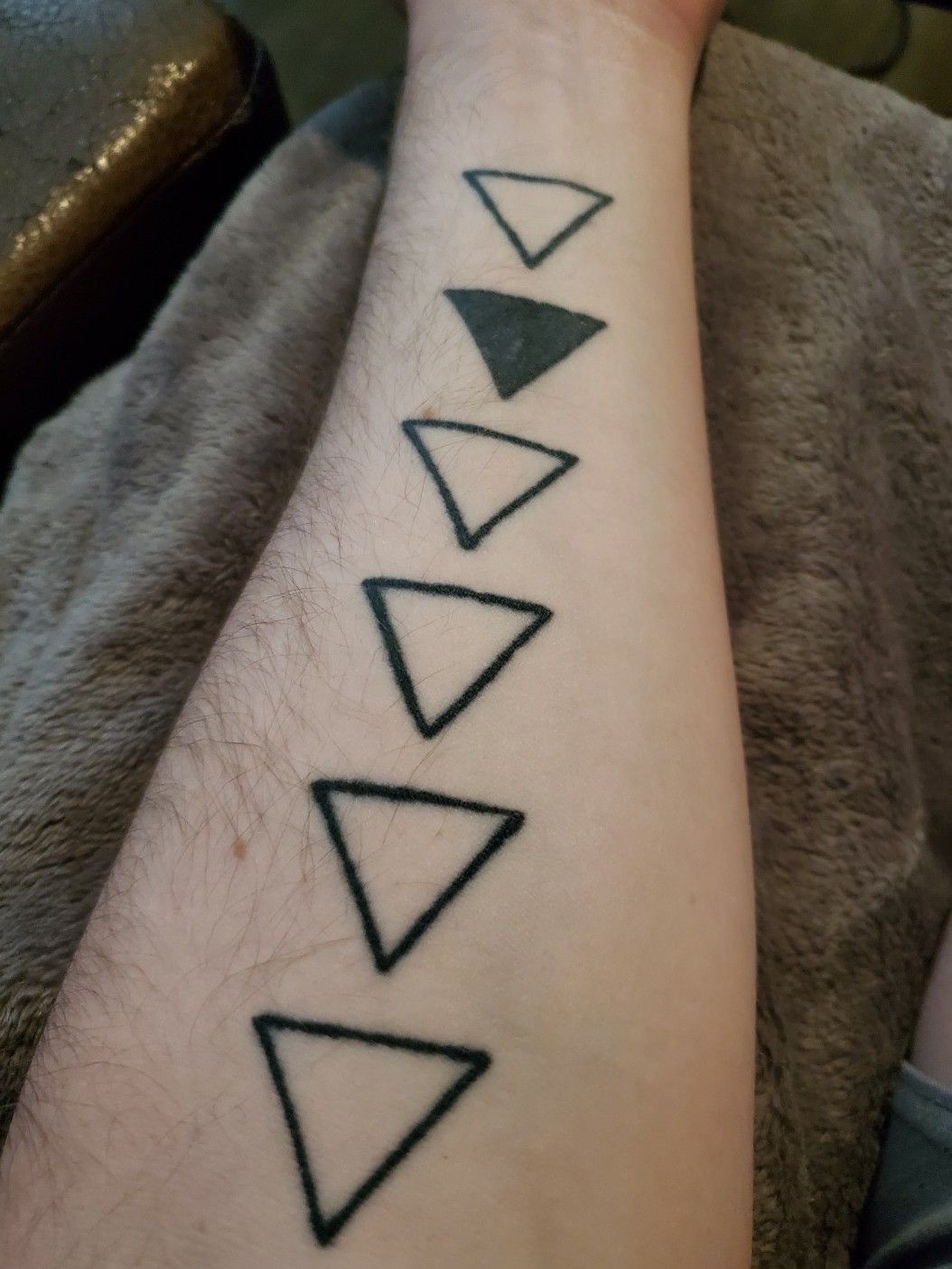 Black triangle order sibling tattoos on upper mid back and arms for sisters