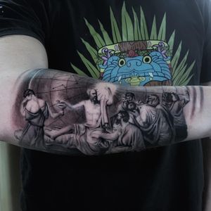 Stunning black and gray forearm tattoo of a man with a beard holding a cup, done in illustrative style by Marcel Oliveira.