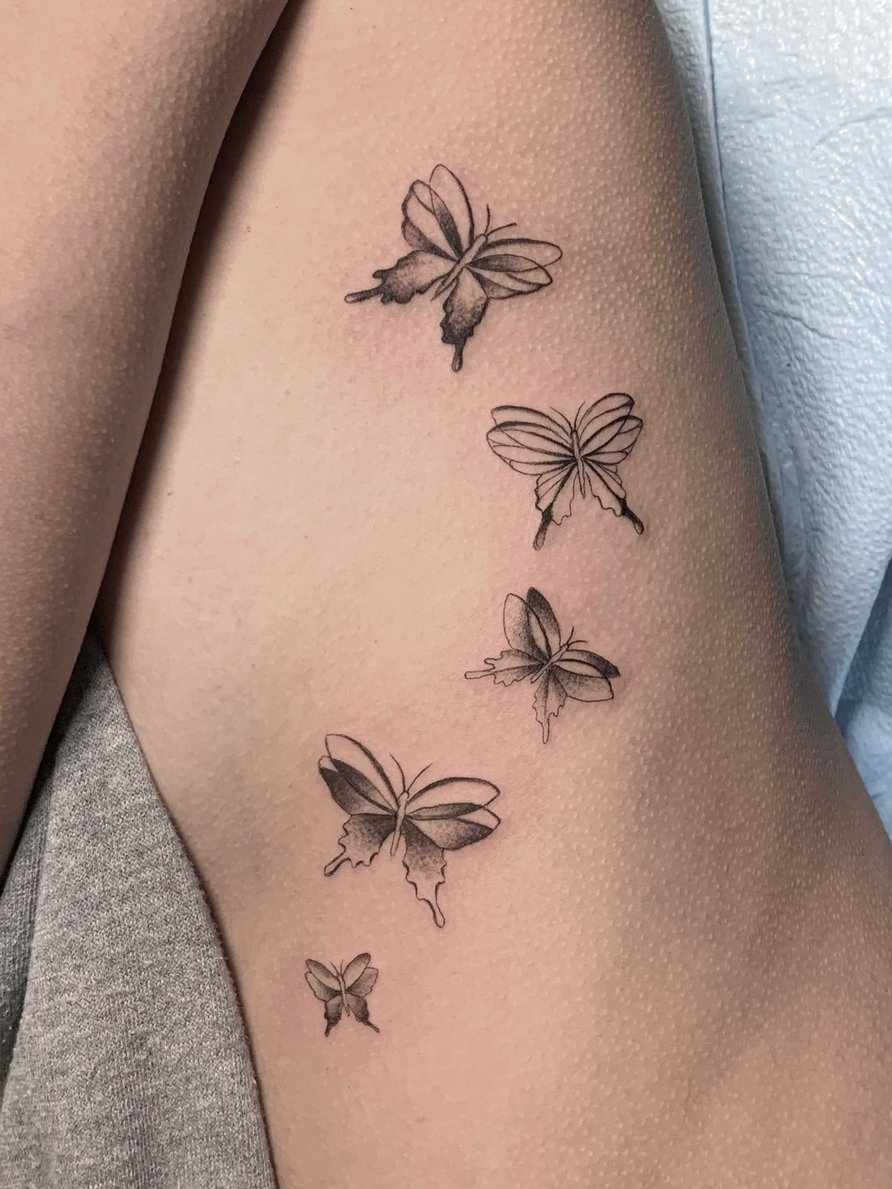 Minimalist butterfly tattoo on the shoulder blade